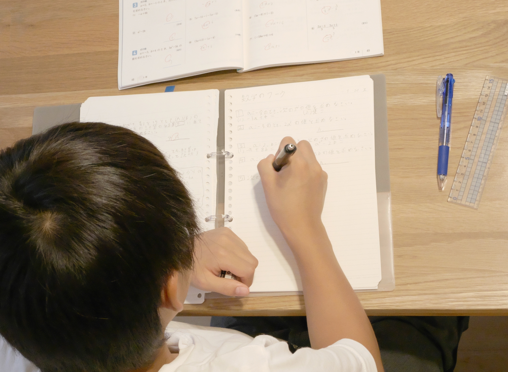 ノートに数学をメモする男子