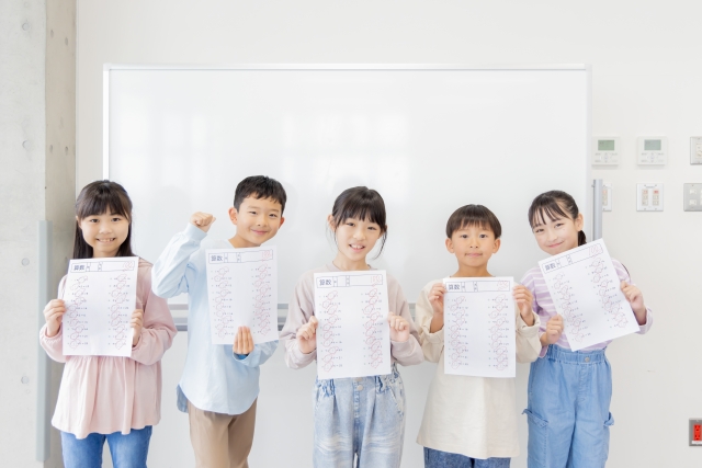 テスト答案を手にもつ児童たち
