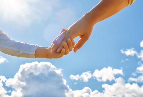 空を背景に親子が手をつなぐ